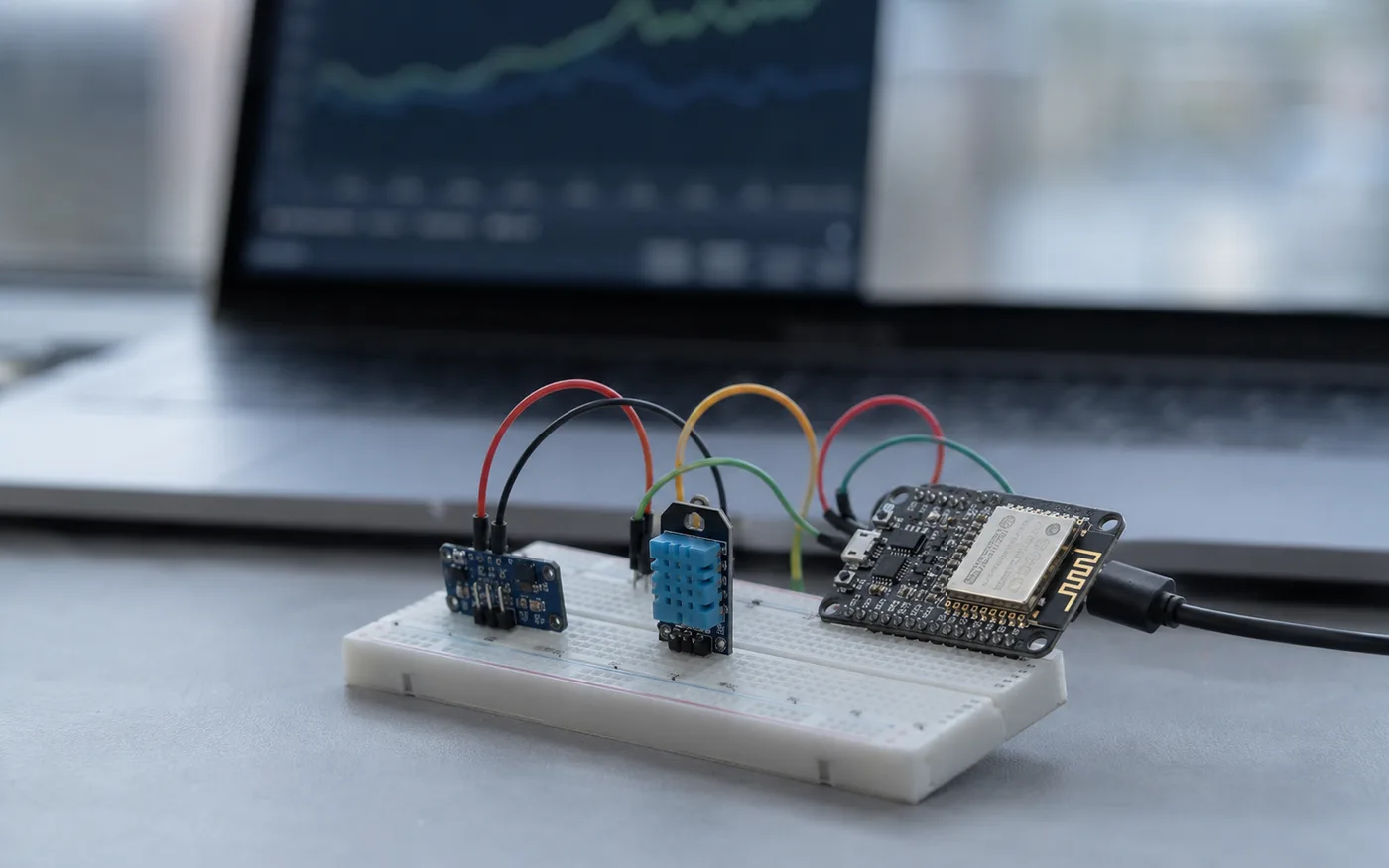 IoT sensor node on a breadboard — microcontroller board wired to a temperature and humidity sensor